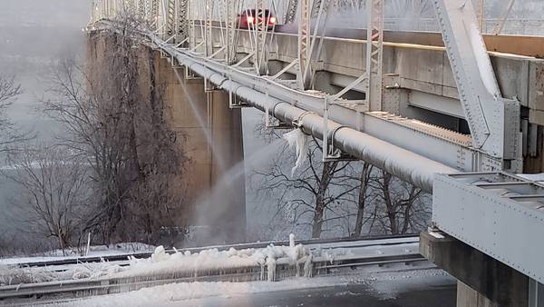 Water sprays from bridge, onto road below in one of several breaks in Pittsburgh area