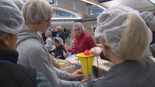 Thousands pack convention center to pack meals for the hungry