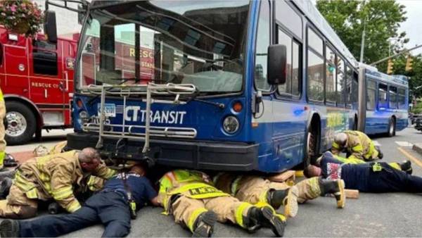 Firefighters save woman trapped under bus