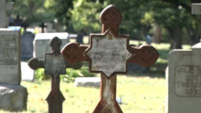 Volunteers work to make sure graves of Benedictine monks in St. Vincent cemetery are taken care of