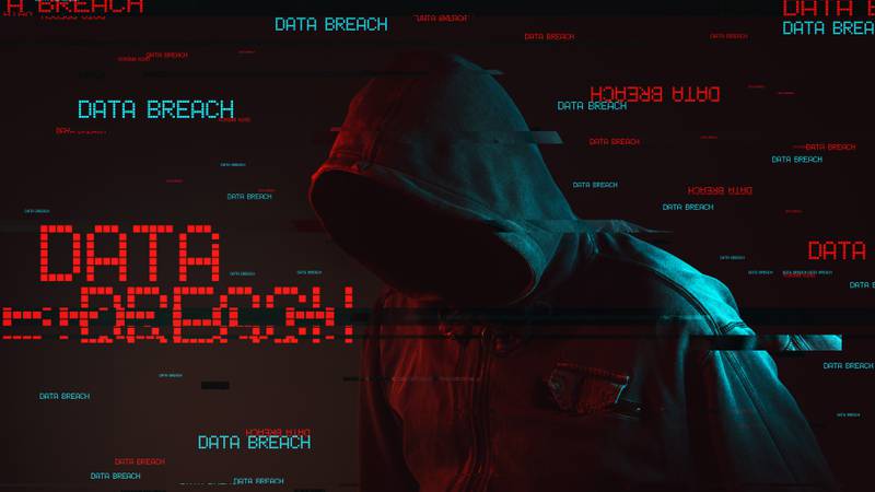 Data breach concept with faceless hooded male person, low key red and blue lit image and digital glitch effect