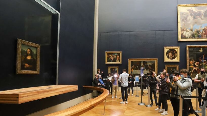 PARIS, FRANCE - MAY 19: A visitor photographs the painting 'La Joconde' The Mona Lisa by Italian artist Leonardo Da Vinci on display in a gallery at Louvre on May 19, 2021 in Paris, France. The country is taking steps to ease the lockdown measures that President Emmanuel Macron announced on April 29, allowing all the museums and non-essential shops and cultural venues to open and rolling back the curfew to 9pm. The cafe and restaurant terraces can also open to 50% capacity. France is reporting a seven-day average of around 14,000 new Covid-19 cases. (Photo by Marc Piasecki/Getty Images)
