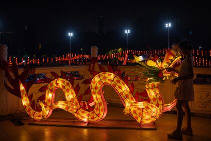 KUALA LUMPUR, MALAYSIA - FEBRUARY 09: A girl admires a dragon decorative lantern during a Lunar New Year celebration at Thean Hou Temple on February 09, 2024, in Kuala Lumpur, Malaysia. Chinese New Year in Malaysia is marked by family gatherings, festive adornments and traditional rituals embodying a spirit of hope and renewal for the year ahead, and aims to bring joy and prosperity to all while fostering a sense of unity and hope for a successful Year of the Dragon. (Photo by Annice Lyn/Getty Images)