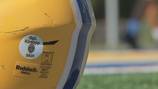 Hampton football team honors police sergeant after his death by wearing badge number on helmets